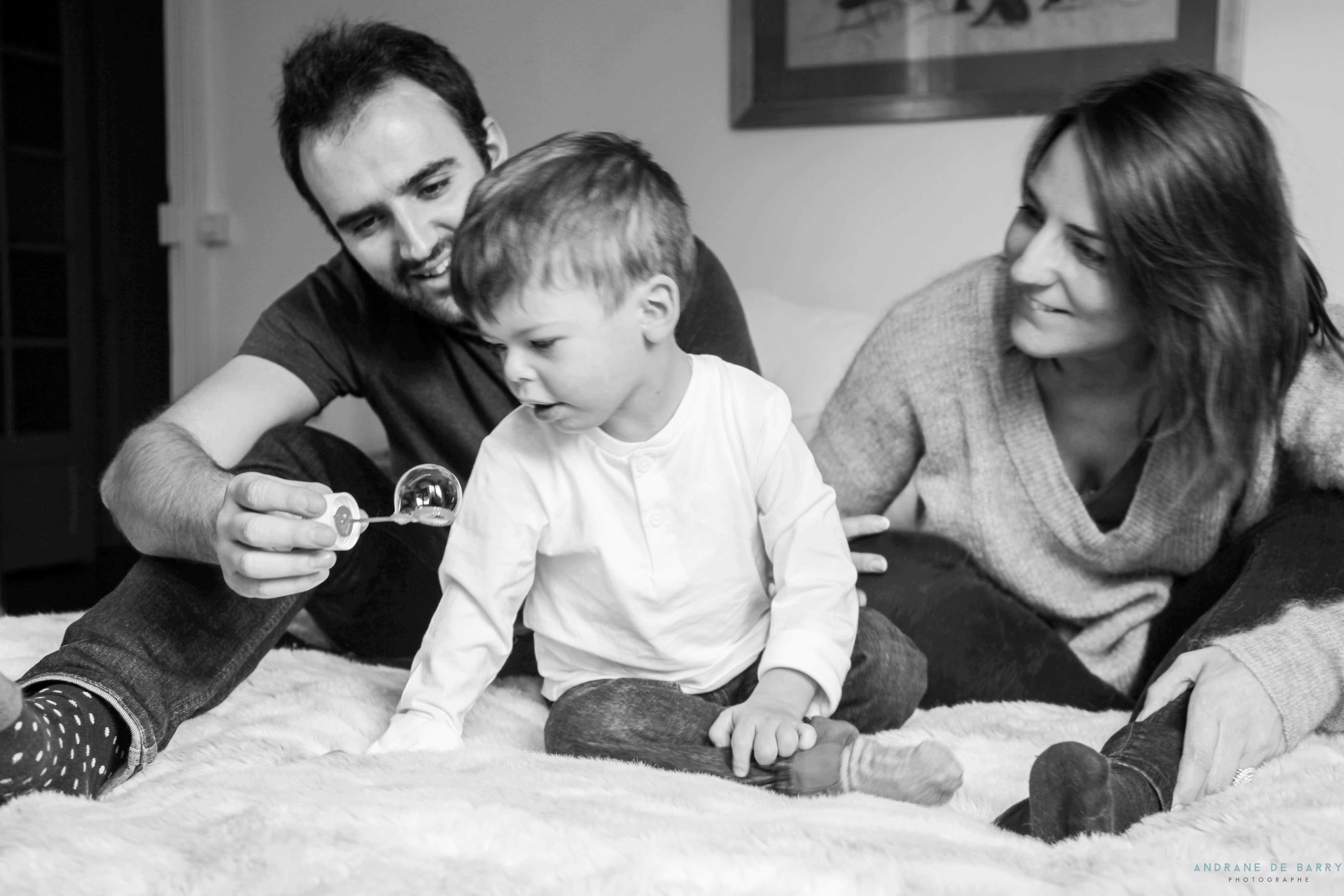 Enfant atteint du syndrome de Williams et Beuren joue aux bulles de savon avec ses parents